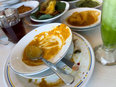 Basit Padang pilavı Padang mutfağından, basit bir Padang restoranında beyaz tabakta servis edilen çeşitli mezelerle servis edilen çeşitli yemeklerden oluşur..