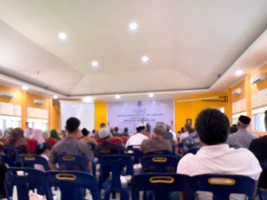 Bir salonda ders çalışmaya katılan insanların bulanık bir fotoğrafı. İnsanlar çalışma odasında dikkatsiz..