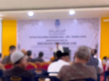 Bir salonda ders çalışmaya katılan insanların bulanık bir fotoğrafı. İnsanlar çalışma odasında dikkatsiz..