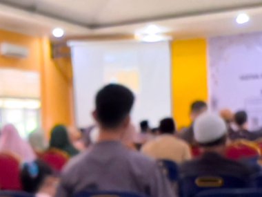 Bir salonda ders çalışmaya katılan insanların bulanık bir fotoğrafı. İnsanlar çalışma odasında dikkatsiz..