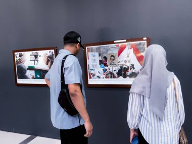 Aceh, Indonesia - juni 22, 2024: A tourist is walking through the corridor of the Aceh Tsunami Museum, with walls displaying photos of the 2004 Aceh tsunami disaster clipart