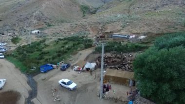 Geleneksel insanlarla nehir vadisinde bir koyun sürüsü ve göçebe yaşam.