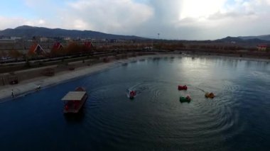 Tekne turistleri ve yapay gölün ve güzel adanın sularındaki insanlar.