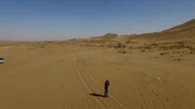 İnsanlar çölde kum tepelerinde eğleniyor. Off-road sürüşü. Develer. tırmanıyor.