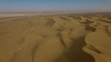 İnsanlar çölde kum tepelerinde eğleniyor. Off-road sürüşü. Develer. tırmanıyor.