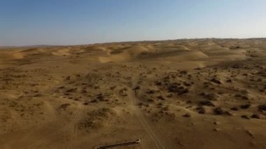 İnsanlar çölde kum tepelerinde eğleniyor. Off-road sürüşü. Develer. tırmanıyor.