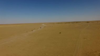İnsanlar çölde kum tepelerinde eğleniyor. Off-road sürüşü. Develer. tırmanıyor.