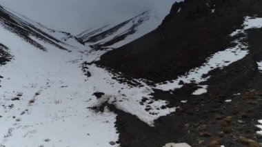 Kocaman karlı dağ ve kar. Karlı dağların arasında İHA ile uçmak.