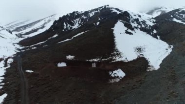 Kocaman karlı dağ ve kar. Karlı dağların arasında İHA ile uçmak.