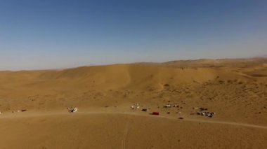 İnsanlar çölde kum tepelerinde eğleniyor. Off-road sürüşü. Develer. tırmanıyor.