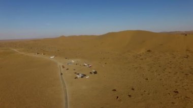 İnsanlar çölde kum tepelerinde eğleniyor. Off-road sürüşü. Develer. tırmanıyor.