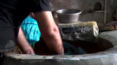Şapkalı bir adam bir bardak su tutuyor.