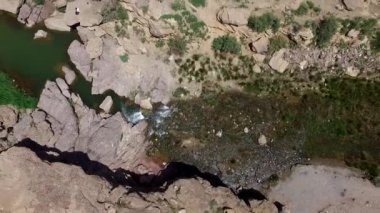 Taşları ve yeşil otları olan yüksek açılı bir nehir manzarası