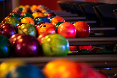 Bowling topları, siyah duvar kâğıdı fotoğrafı. Bowling salonu için sanatsal bir resim. Bowling salonunda bir sürü bovling topu hazırlandı. Kapat.