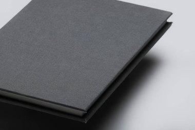 Gri yüzen kitap modeli. Beyaz arka planda izole edilmiş gölgeli boş bir kitabın stüdyo görüntüleri. Üç Boyut