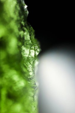 Genuine bohemian moldavite gemstone close up. Tektite, natural glass formed during a meteorite impact. Beautiful green gemstone. Precious rare mineral. Illegal mining of moldavites in Czechia. Alternative therapy. clipart