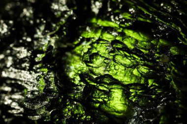 Genuine bohemian moldavite gemstone close up. Tektite, natural glass formed during a meteorite impact. Beautiful green gemstone. Precious rare mineral. Illegal mining of moldavites in Czechia. Alternative therapy. clipart