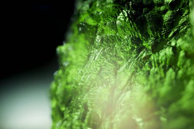 Genuine bohemian moldavite gemstone close up. Tektite, natural glass formed during a meteorite impact. Beautiful green gemstone. Precious rare mineral. Illegal mining of moldavites in Czechia. Alternative therapy. clipart