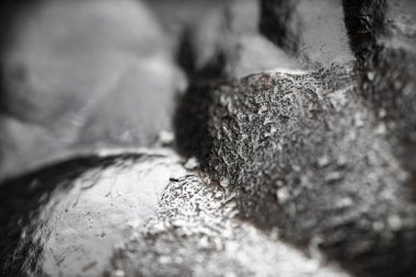 Çiğ hematite yakın çekim. Demir cevheri yüzeyi, gri yansıtıcı mineral dokusu.