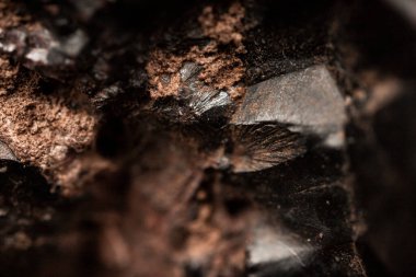 Çiğ hematite yakın çekim. Demir cevheri yüzeyi, gri yansıtıcı mineral dokusu.