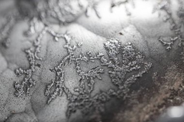 Çiğ hematite yakın çekim. Demir cevheri yüzeyi, gri yansıtıcı mineral dokusu.