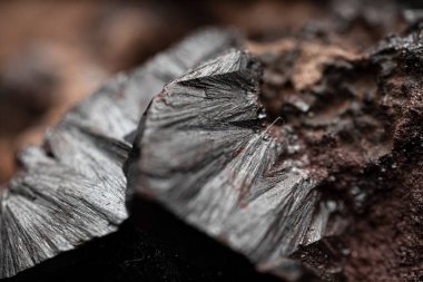 Çiğ hematite yakın çekim. Demir cevheri yüzeyi, gri yansıtıcı mineral dokusu.