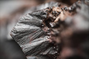 Çiğ hematite yakın çekim. Demir cevheri yüzeyi, gri yansıtıcı mineral dokusu.