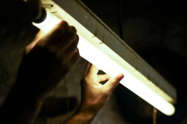 Erkekçe kollar keskinleştiriyor ve çekiç kullanarak eski bir bıçağı onarıyor.