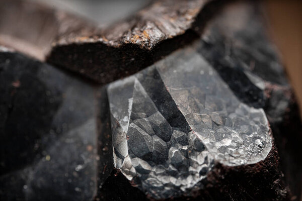 Close-up of raw hematite. Surface of iron ore. Grey reflective mineral texture