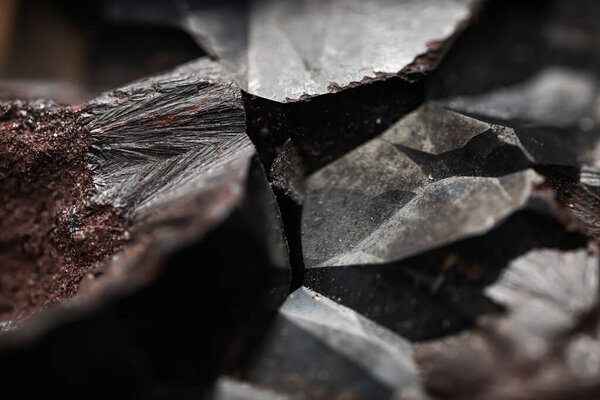 Close-up of raw hematite. Surface of iron ore. Grey reflective mineral texture