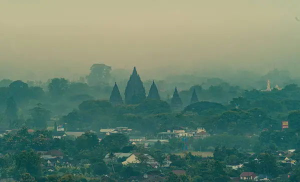 Yeşil evler ve ağaçlarla çevrili Prambanan Tapınağı 'nın muhteşem manzarası ve Yogyakarta Endonezya' da eşlik eden sis..