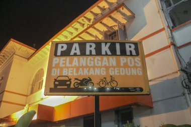 Araç simgeleri olan bir binanın önündeki park işareti