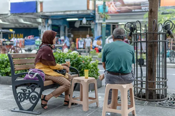 İnsanlar Endonezya 'da bir bankta oturup sohbet ediyorlar.