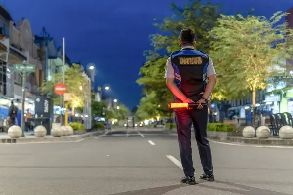Endonezya 'nın bir şehrinde trafik müdürü gece trafiğini yönetiyor.