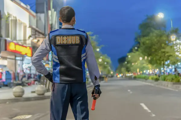 Endonezya 'nın bir şehrinde trafik müdürü gece trafiğini yönetiyor.