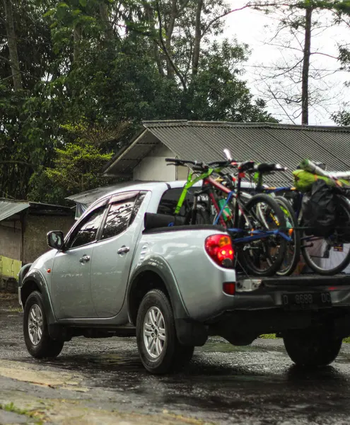 Yoldaki dağ bisikletleriyle dolu gümüş bir kamyonet.