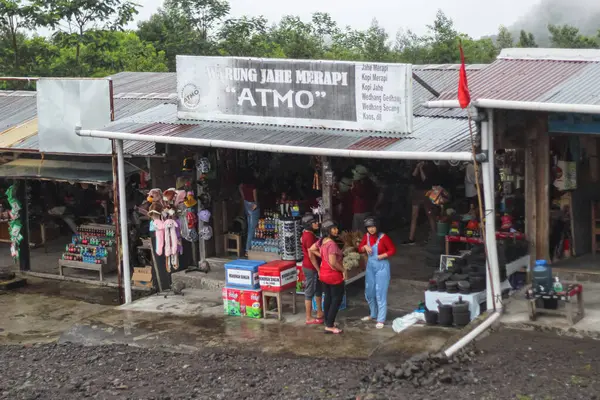 Önünde insanlar ve mallar olan hareketli bir dükkan..