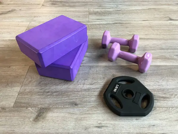 Fitness equipment for Yoga Pilates on the wooden floor: Purple Yoga Blocks, Purple Neoprene Coated Hexagon Workout Dumbbell Hand Weigh