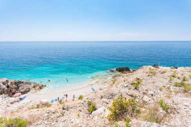 Porto Palermo Arnavutluk - 5 Temmuz. 2023: küçük gizli bir plajda yıkanan turistler