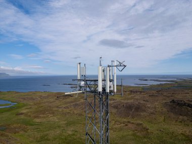 Antennas on a mast in the Icelandic countryside clipart