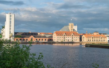 buildings bear the river in city of Odense in Denmark on a sunny summer day clipart