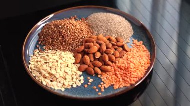 Badem, yulaf, karabuğday, chia tohumu, sergilenen mercimek gibi vejetaryen malzemeler. Sağlığı ve gezegeni destekleyen besleyici bitkisel beslenmeler için sürdürülebilir, çevre dostu temel gereksinimler. Vejetaryen yemeği