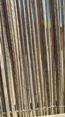 Doğal malzemelerden ve ağaç dallarından yapılmış kaba desenli ahşap çitler. Bu kültürel ahşap yapı bölge mirasını ve geleneksel tasarımı ön plana çıkarıyor. Otantik işçilik