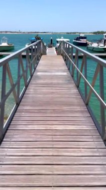 Rıhtımlara doğru yürürken limanın huzurlu ve sakin atmosferini vurgulayarak rahatlama ve manzaralı güzellik macerası üzerine odaklanmış tekneler rıhtıma yanaştı.