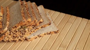 Tohumlu glütensiz ekmek dilimleri, çevre dostu, vegan malzemelerden yapılmış, ahşap masada dinleniyor. Bitki temelli, glütensiz diyet yapan herkes için sağlıklı ve lezzetli bir seçenek..