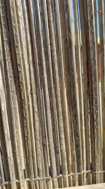 Doğal malzemelerden ve ağaç dallarından yapılmış kaba desenli ahşap çitler. Bu kültürel ahşap yapı bölge mirasını ve geleneksel tasarımı ön plana çıkarıyor. Otantik işçilik