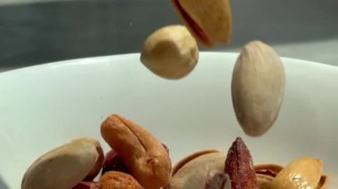 Çeşit çeşit fındıklar beyaz kaseye doluşur, sağlık, enerji ve temel mineralleri taşır. Besleyici atıştırmalıklar için mükemmel, doğal güzelliklerle dolu. Sağlıklı, enerjik, mineral zengini..