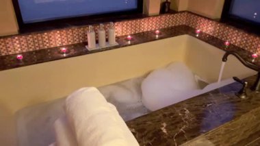 Şatafatlı Arap tarzı banyo kombinasyonu güzel dekor ve mum ışığı zarif bir ortam yaratır. Kabarcıklarla dolu bir banyo, akan musluk suyu, yumuşak havlular, mumlar egzotik atmosfer yaratır..