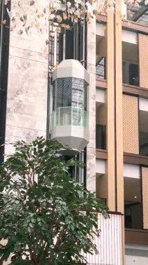  5 yıldızlı oteldeki cam asansör kabini modern tasarım ve tavandan sarkan karmaşık dekorasyonlarla sarmalanmış lüks ve çağdaş tarzda misafir deneyimini geliştiriyor.