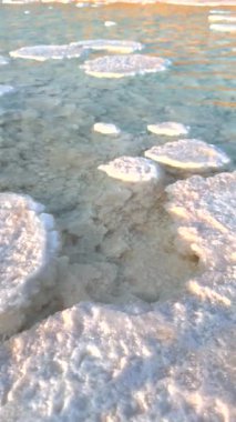 Beyaz tuz birikintileri turkuaz su güneş ışığına dönüşür. Katı tuz ile su dengeleyici kristal oluşumlar ve dikey video. 